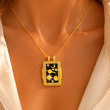 18K gold plated stainless steel rectangular pendant necklace with black enamel-style centre, moon, stars, planet details and crystal-style border.
