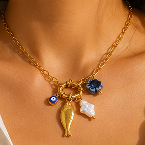Gold necklace with charms on a beige background
