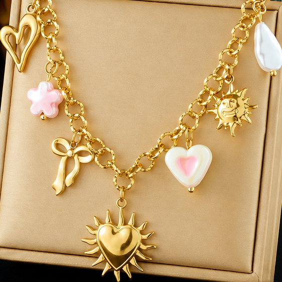 Gold-plated sun heart charm necklace with butterfly bow, flower, pearl and heart charms on a chunky link chain.