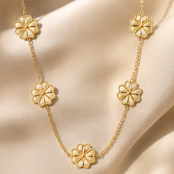 Golden flower charm necklace with five textured floral charms on a fine gold chain.