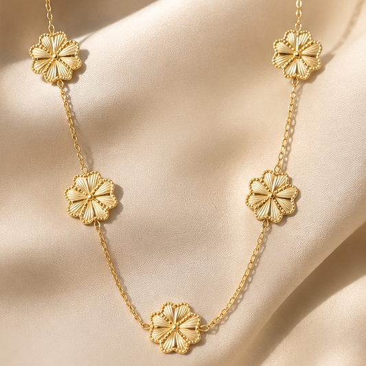 Golden flower charm necklace with five textured floral charms on a fine gold chain.