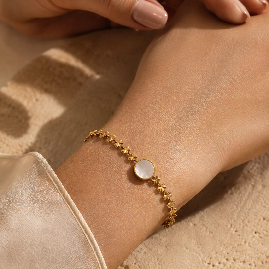 A delicate gold bracelet with clover-inspired chain detailing and a luminous shell-style centre charm. Lightweight, feminine and easy to wear solo or layered.